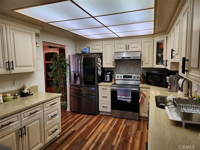 kitchen featuring cream cabinets, sink, tasteful backsplash, dark hardwood / wood-style flooring, and stainless steel appliances