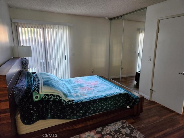 bedroom featuring a textured ceiling, a closet, and dark hardwood / wood-style floors