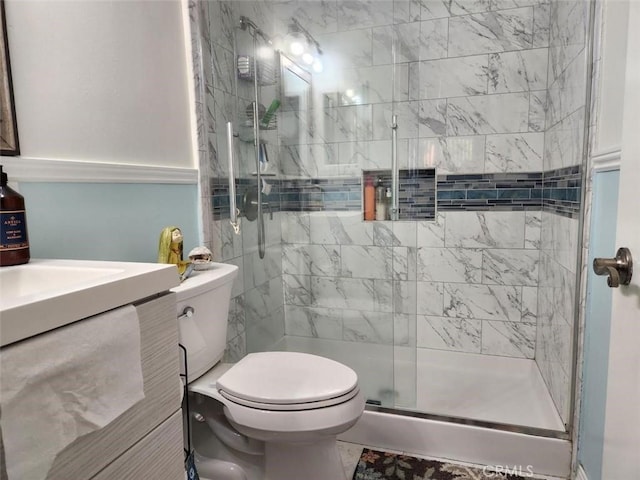 bathroom with toilet, vanity, and walk in shower