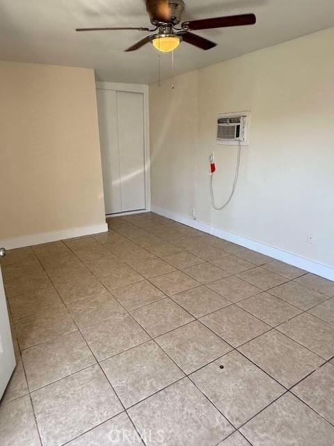 tiled empty room with ceiling fan and a wall mounted air conditioner