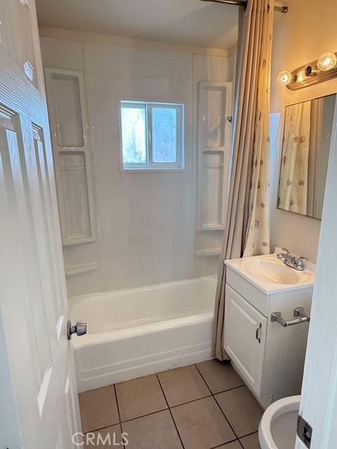 full bathroom featuring toilet, vanity, tile patterned flooring, and shower / bath combo with shower curtain