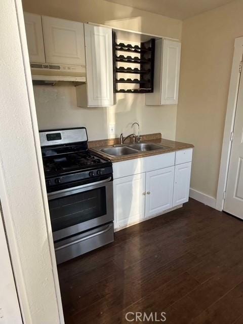 kitchen featuring dark wood-type flooring, white cabinetry, stainless steel range with gas cooktop, and sink