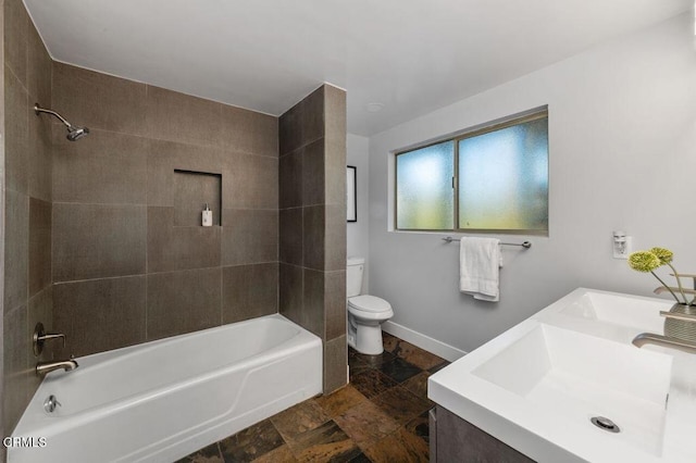 full bathroom featuring bathtub / shower combination, toilet, stone tile floors, a sink, and double vanity