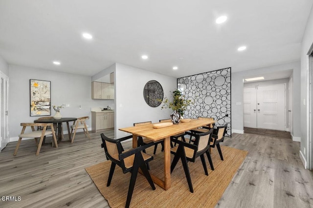 dining area with recessed lighting, light wood-style flooring, and baseboards