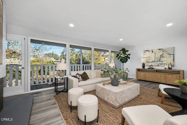 living area featuring baseboards, wood finished floors, visible vents, and recessed lighting