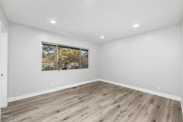 spare room with recessed lighting, baseboards, visible vents, and light wood finished floors