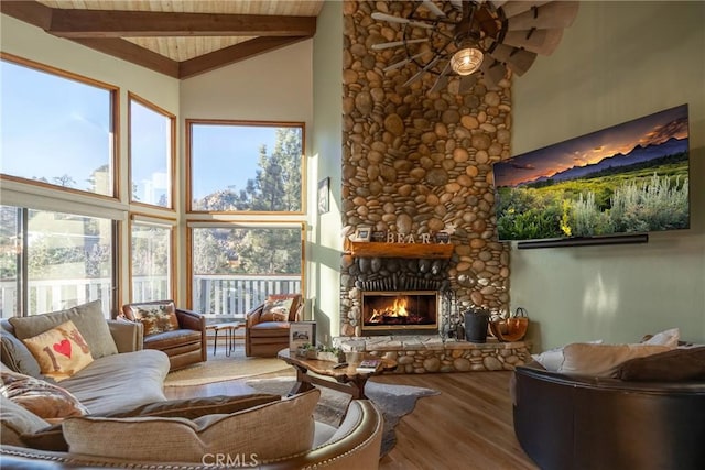 living room featuring beam ceiling, ceiling fan, high vaulted ceiling, hardwood / wood-style floors, and a fireplace