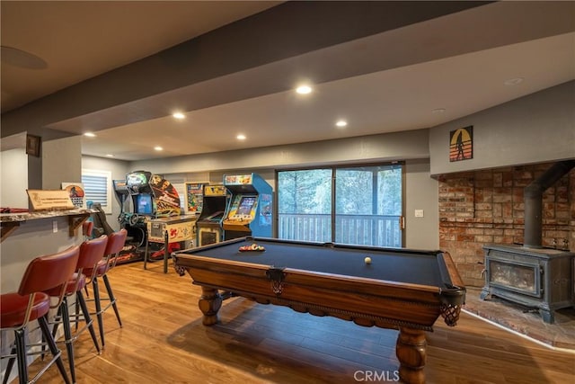 playroom featuring light wood-type flooring, a wood stove, and billiards