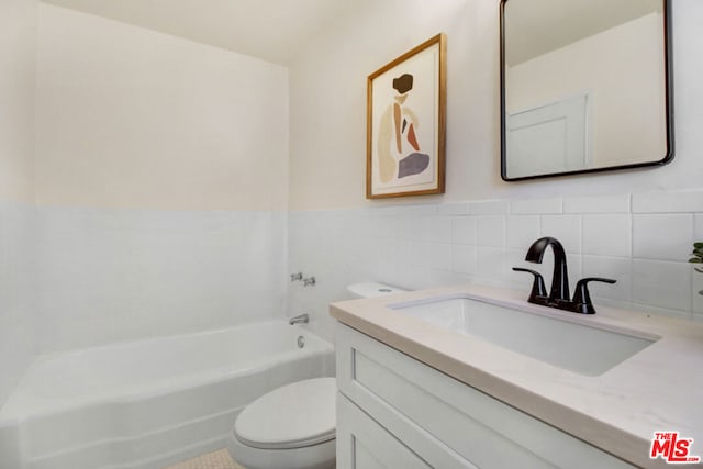 bathroom with vanity, tile walls, and toilet