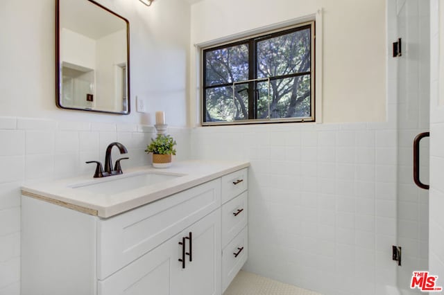 bathroom featuring vanity and tile walls