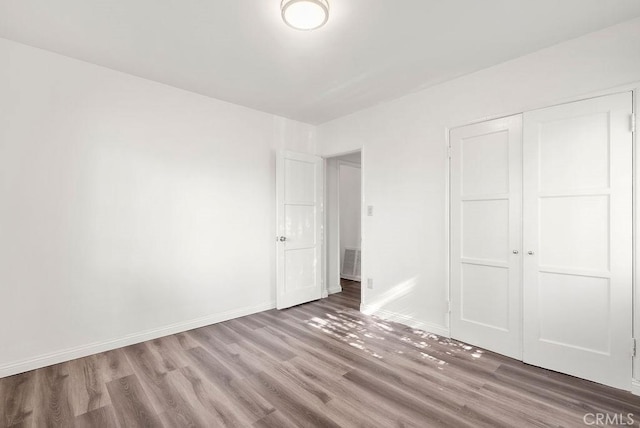 unfurnished bedroom with a closet and hardwood / wood-style floors