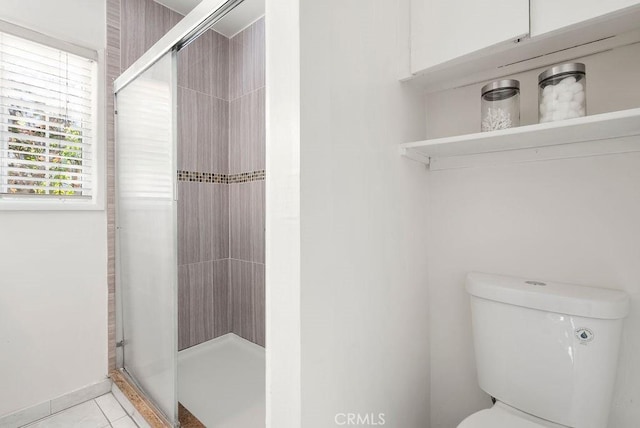 bathroom featuring tile patterned floors, an enclosed shower, and toilet