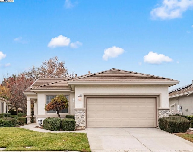 view of front of home with a front yard and a garage