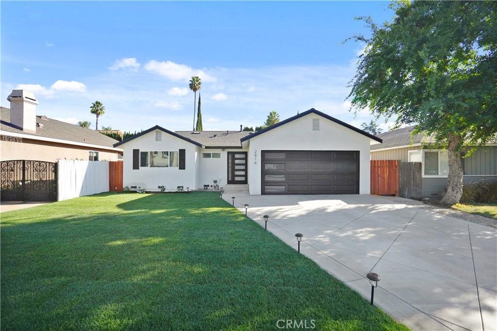 ranch-style house featuring a garage and a front lawn