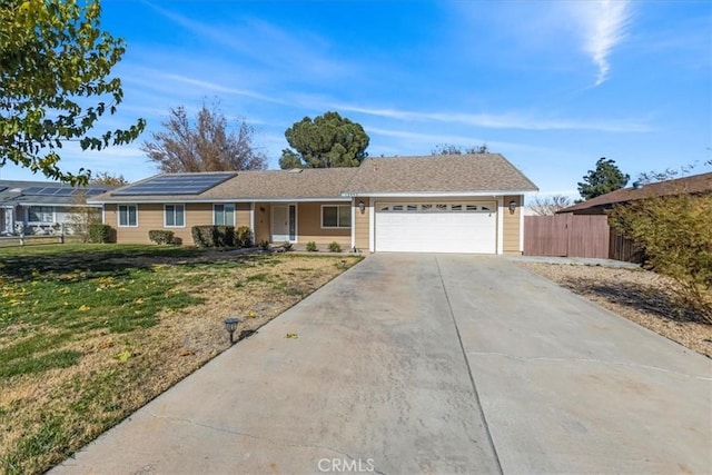 ranch-style house featuring solar panels, a garage, and a front lawn