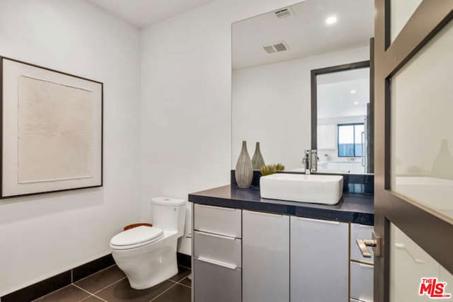 bathroom featuring tile patterned flooring, vanity, and toilet