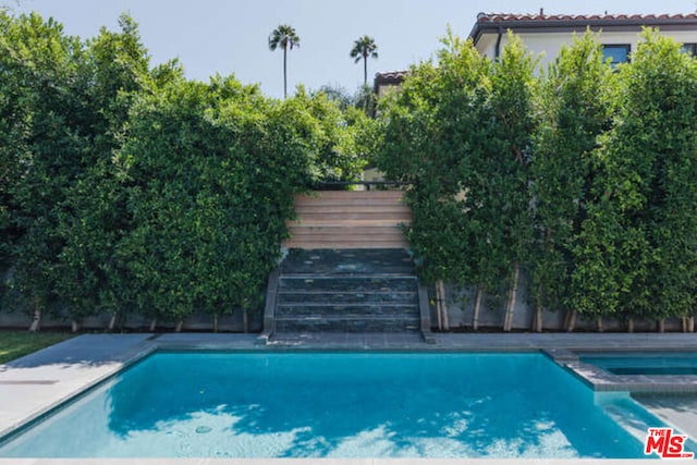 view of swimming pool with an in ground hot tub