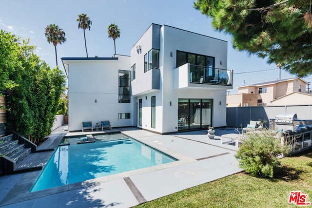 rear view of house featuring a balcony and a patio