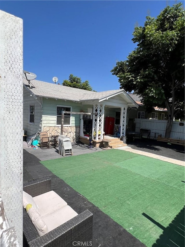 back of house with a lawn and a patio area