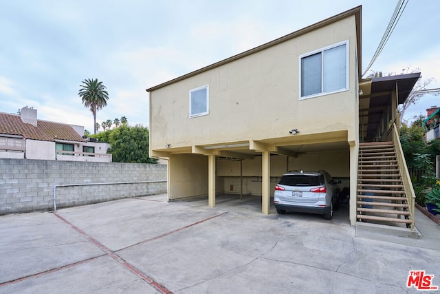 back of house featuring a carport