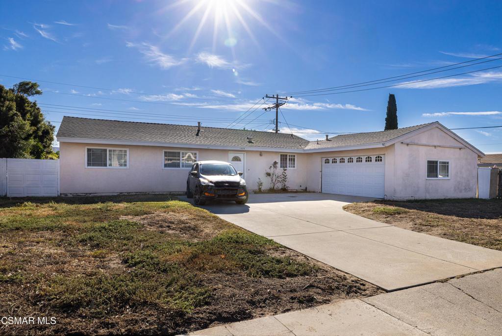 ranch-style house with a garage and a front lawn