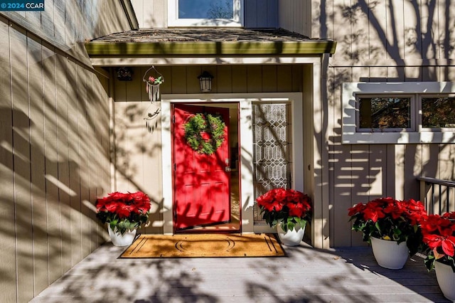 view of exterior entry featuring a wooden deck