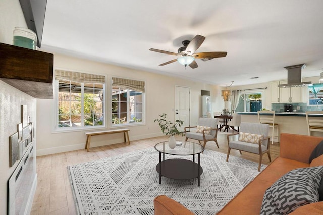 living room with ceiling fan and light hardwood / wood-style floors