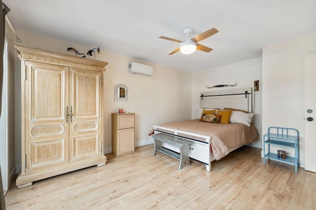 bedroom with ceiling fan, light hardwood / wood-style floors, and an AC wall unit