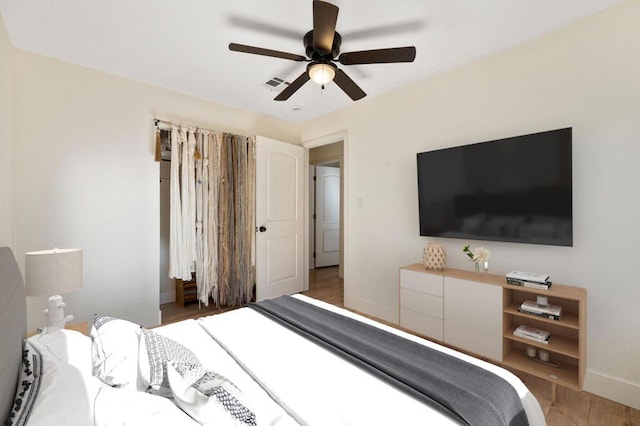 bedroom with dark hardwood / wood-style flooring and ceiling fan