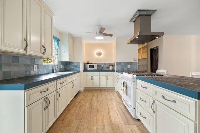 kitchen with island range hood, sink, backsplash, kitchen peninsula, and white appliances