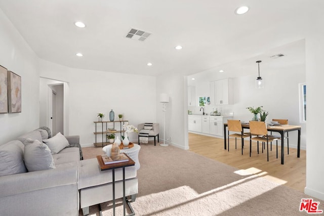 living room with light hardwood / wood-style flooring and sink