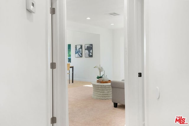 hallway featuring light colored carpet