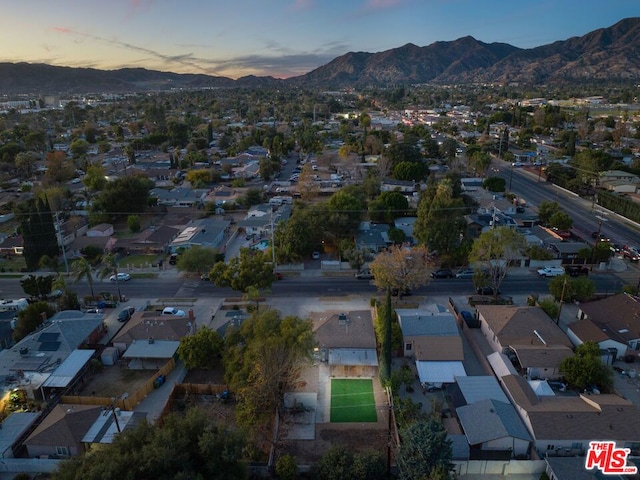 aerial view at dusk featuring a mountain view