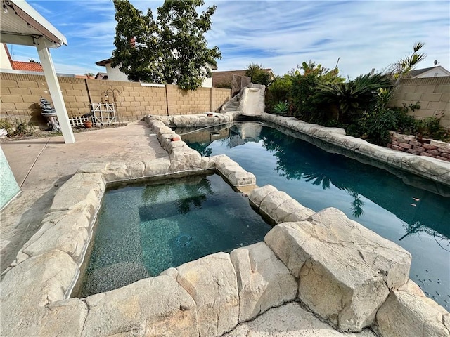 view of pool with an in ground hot tub