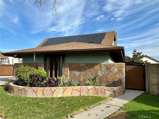 view of side of home featuring a yard and solar panels