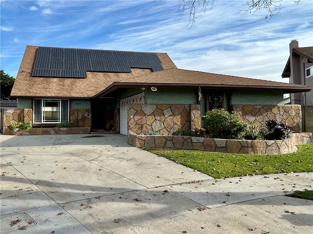 view of front of property featuring a garage and solar panels