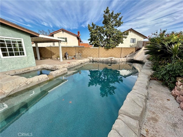 view of swimming pool with an in ground hot tub