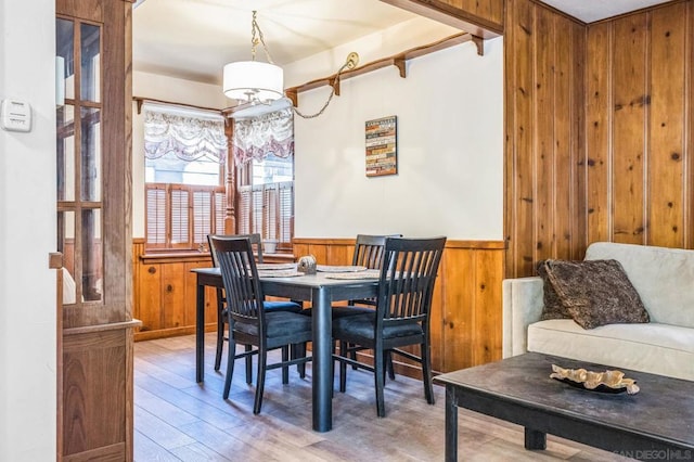 dining space featuring wooden walls and wood-type flooring