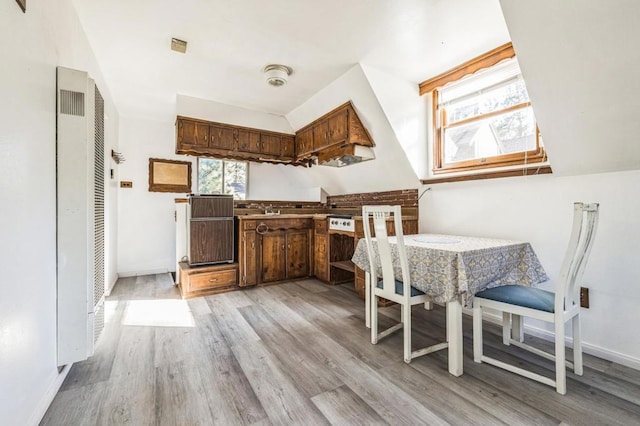 kitchen with black dishwasher and light hardwood / wood-style flooring