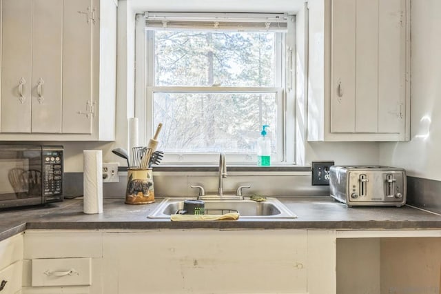 kitchen with white cabinetry and sink