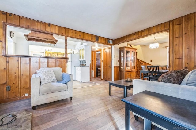 living room featuring hardwood / wood-style floors and wooden walls