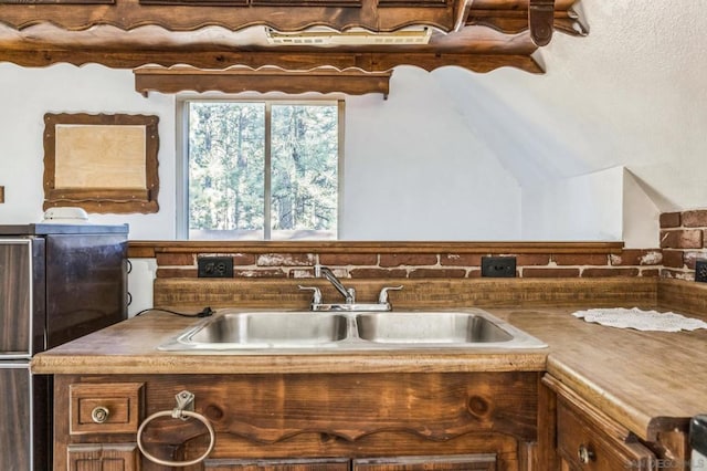 kitchen featuring refrigerator and sink