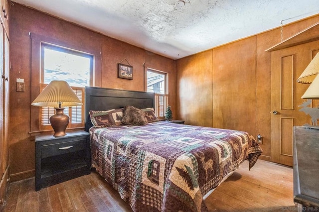 bedroom with wood-type flooring and a textured ceiling