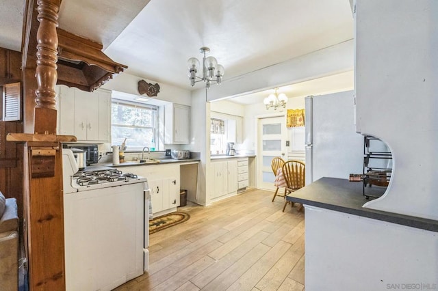 kitchen featuring a notable chandelier, white cabinetry, white appliances, and light hardwood / wood-style flooring