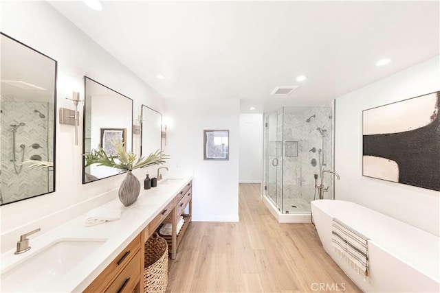 bathroom featuring hardwood / wood-style floors, vanity, and shower with separate bathtub