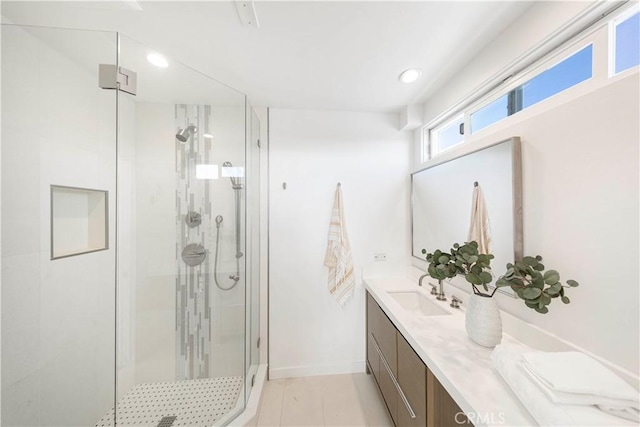 bathroom with a shower with shower door and vanity