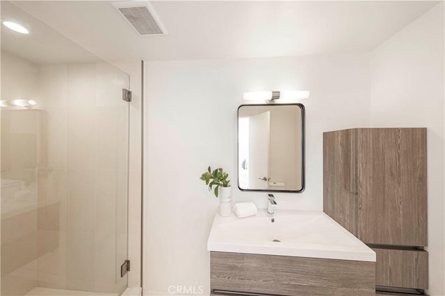 bathroom with a shower with shower door and vanity