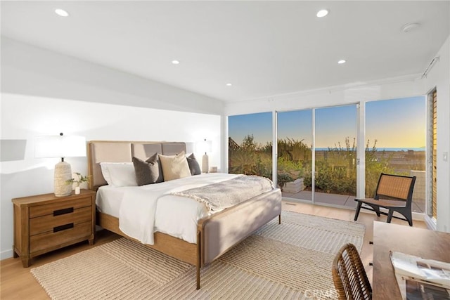 bedroom with multiple windows, access to outside, and light wood-type flooring