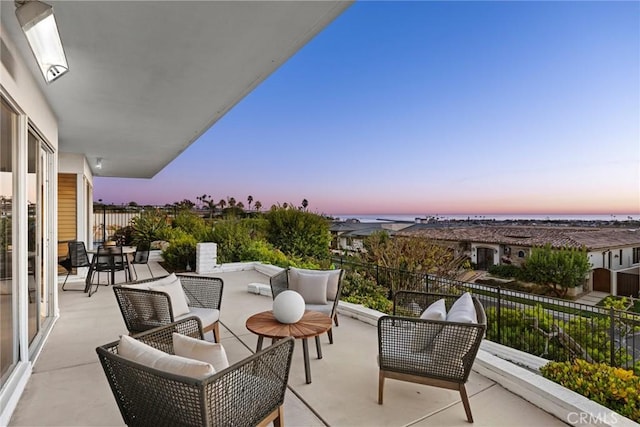 balcony at dusk featuring an outdoor living space