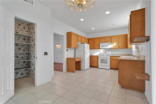 kitchen with sink, an inviting chandelier, decorative light fixtures, white appliances, and light tile patterned floors